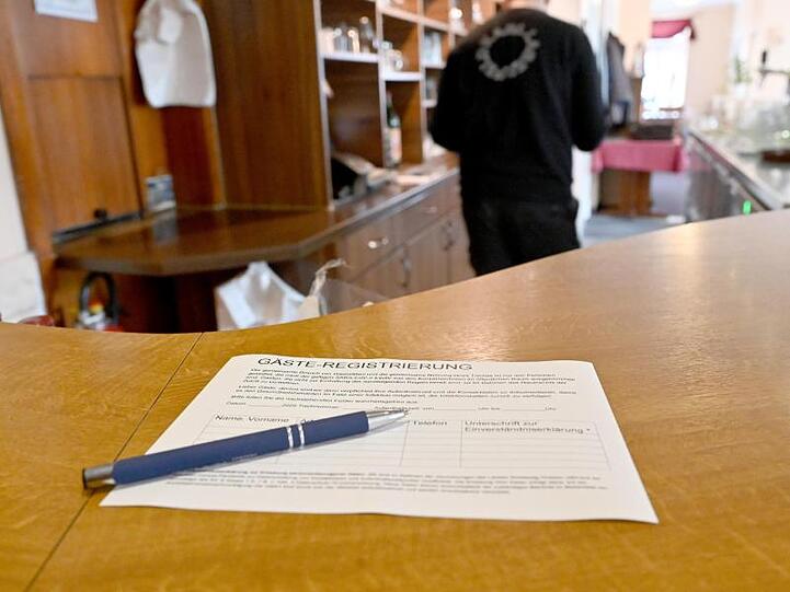 Ein Zettel für die Gäste-Regstrierung liegt in einem Restaurant auf einem Tisch. Die große Mehrheit der Kunden füllt diese Registrierung als Corona-Vorsorge wahrheitsgemäß aus.