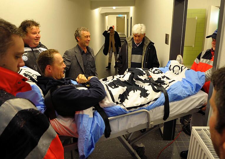 Olaf Bodden wird auf einem Krankenbett auf den Rasen des Grünwalder Stadions gefahren.
