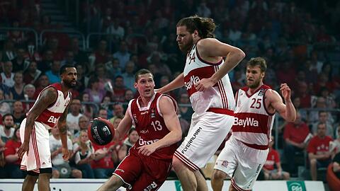 Ungleiches Duell: Bayerns Center John Bryant (r.) gegen Bambergs Janis Strelnieks. Anton Gavel (r.) und Bryce Taylor schauen zu.