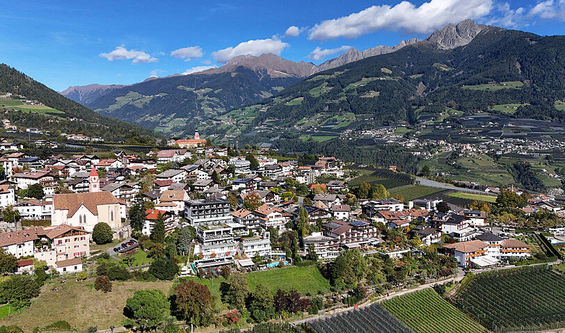Blick auf den Ort Dorf Tirol von der Kurstadt Meran mit Häusern, Hotels und Pfarrkirche. Werden noch mehr Betten benötigt? Blick auf den Ort Dorf Tirol von der Kurstadt Meran mit Häusern, Hotels und Pfarrkirche. Werden noch mehr Betten benötigt?