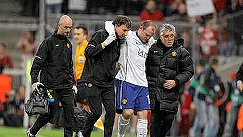 Wayne Rooney wird von Betreuern vom Platz geführt.