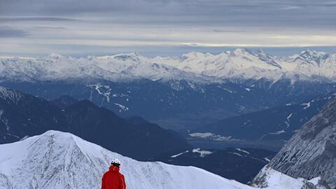 Ein Skifahrer startet auf der Zugspitze vor dem Panorama der Alpen. Foto: Karl-Josef Hildenbrand