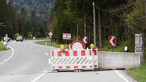 Absperrgitter stehen aneinandergelehnt am Fahrbahnrand der deutsch-österreichischen Grenze. (Archivfoto)