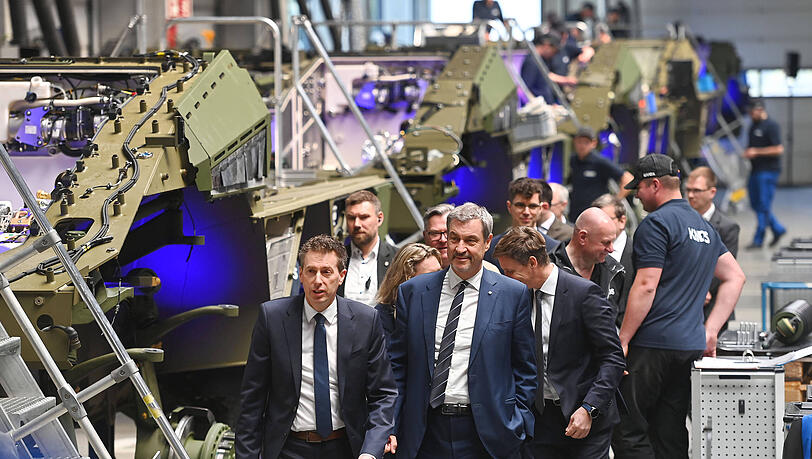 Der bayerische Ministerpr&auml;sident Markus S&ouml;der (Mitte) will die R&uuml;stungsbranche in Bayern weiter f&ouml;rdern. Bei der Besichtigung einer Produktionsfertigungsstra&szlig;e in M&uuml;nchen im April sah er auch den Radpanzer Boxer von KNDS.