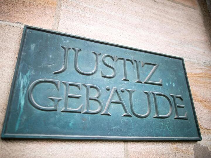 Ein Schild mit der Aufschrift "Justizgebäude" hängt am Eingang am Landgericht Nürnberg-Fürth. Foto: Daniel Karmann/Archiv
