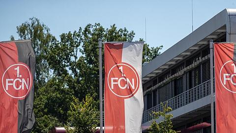 Fahnen mit dem FCN-Logo wehen vor dem Vereinsgebäude.
