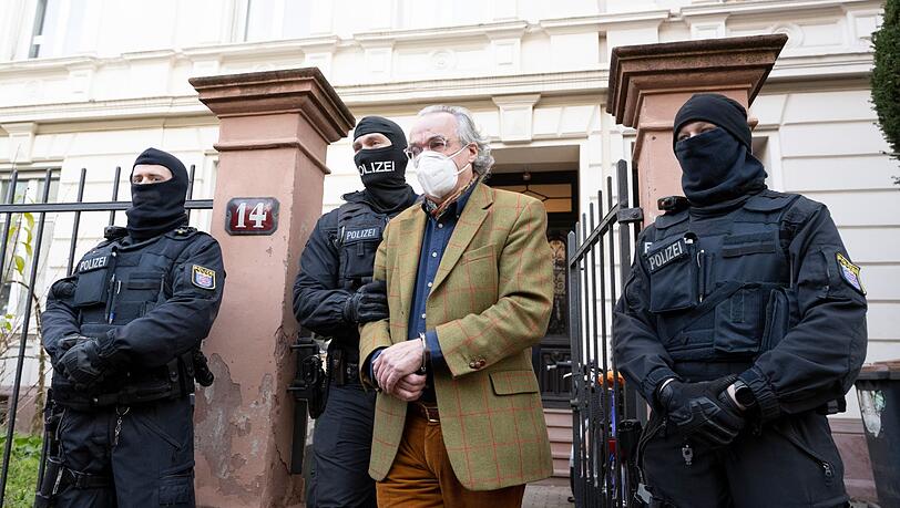 Bei einer Razzia gegen "Reichsbürger" führen vermummte Polizisten nach der Durchsuchung eines Hauses Heinrich XIII. Prinz Reuß (2.v.r.) zu einem Polizeifahrzeug.