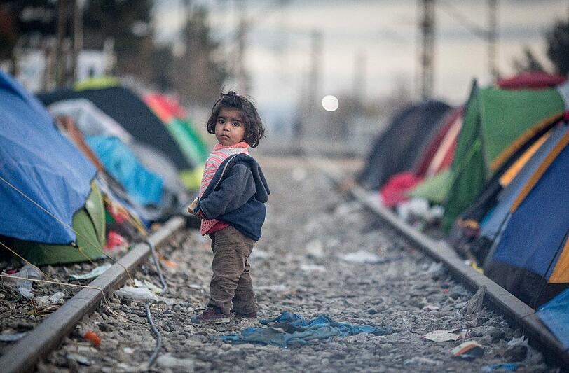 Ein Mädchen steht in Idomeni im Flüchtlingslager an der Grenze zwischen Griechenland und Mazedonien im Gleisbett. Foto: Kay Nietfeld/Archiv