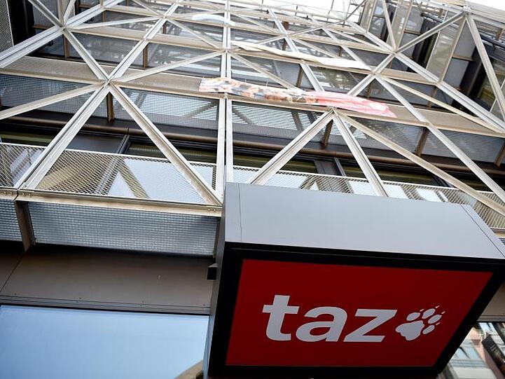 Das Logo der Tageszeitung "taz" ist am Eingang des Redaktionsgebäudes in Berlin-Mitte zu sehen.