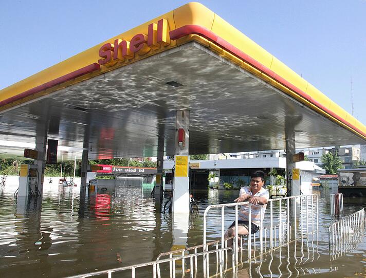 Das Hochwasser bedroht die Energieversorgung, hier: wartet ein Tankstellenbesitzer auf Rettung.