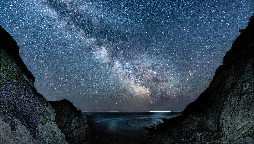 Atemberaubender Ausblick: Die Milchstraße und ein Meteor bei Porthgwarra, einem kleinen Küstendorf in Cornwall nahe Land's End - fotografiert von Jen Rogers. Atemberaubender Ausblick: Die Milchstraße und ein Meteor bei Porthgwarra, einem kleinen Küstendorf in Cornwall nahe Land's End - fotografiert von Jen Rogers.