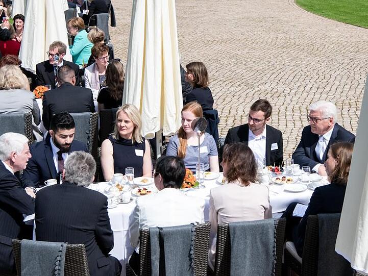 Steinmeier (r) unterhält sich bei der Geburtstagskaffeetafel im Park vom Schloss Bellevue mit geladenen Gästen.