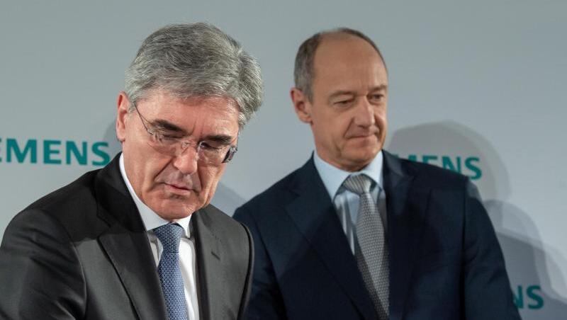 Joe Kaeser (l), Vorstandsvorsitzender von Siemens, und Roland Busch, Stellvertretender Vorstandsvorsitzender und Technischer Direktor (CTO) der Siemens AG, stehen nach einer Pressekonferenz im Rahmen der Siemens-Hauptversammlung in der Olympiahalle zusammen.