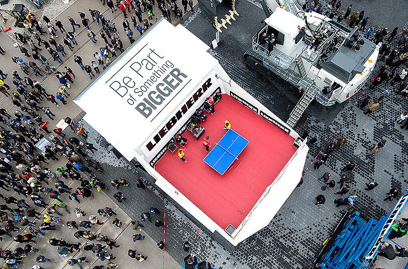 Außergewöhnliche Spielstätte auf der Bauma-Messe. Eine Tischtennis-Platte auf einem Muldenkipper.