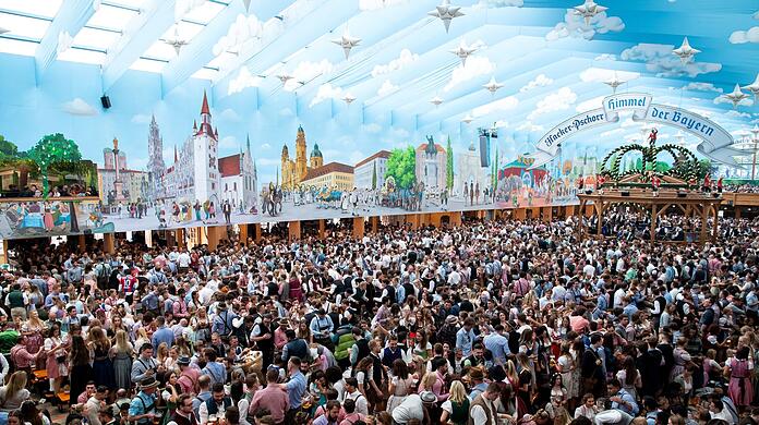 Beim Oktoberfest feiern Wiesnbesucher in einem Festzelt.