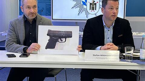 Polizeisprecher Christian Drexler und der Leiter des Kommissariats 51 Stefan Wittmann zeigen ein Foto der scharfgestellten Waffe, die im Fahrzeug des Trios sichergestellt worden ist.
