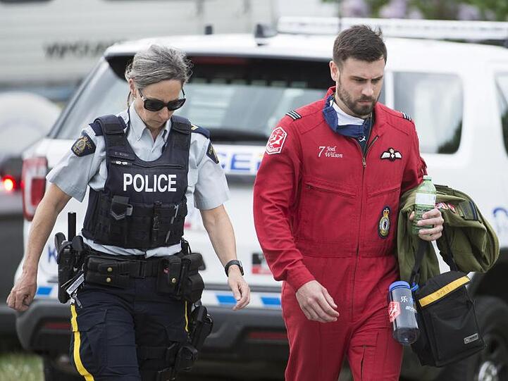 Ein Pilot geht mit einer Polizistin an der Absturzstelle vorbei.