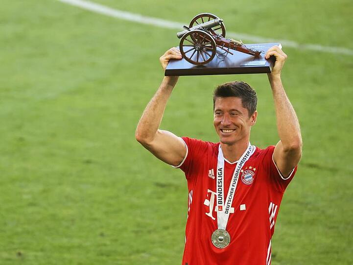 Robert Lewandowski hält nach dem Spiel gegen Wolfsburg die Trophäe für den Torschützenkönig. Foto: Kai Pfaffenbach/Reuters-Pool/dpa