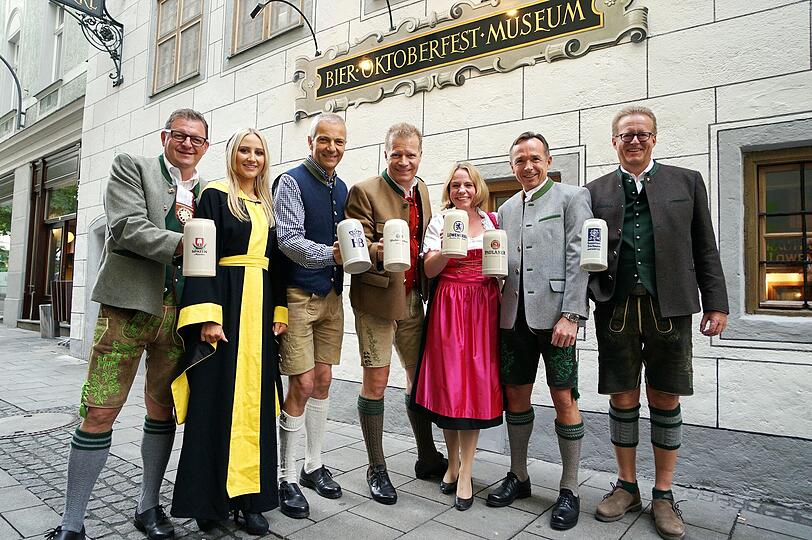Das Münchner Kindl Laila Noeth im traditionellen schwarz-gelben Gewand mit den Chefs der hiesigen Brauereien.