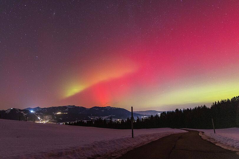 Polarlichter sind in der Nacht &uuml;ber der Landschaft im Oberallg&auml;u mit der H&ouml;rnerkette zu sehen