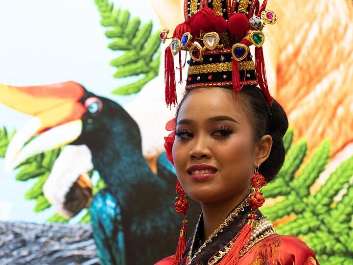 Eine Frau mit einem traditionellen malaysischen Kopfschmuck beobachtet die Eröffnung der Reisemesse ITB auf dem Messegelände in Berlin. Malaysia ist das Partnerland der 53. ITB.