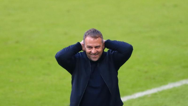 Münchens Trainer Hansi Flick fasst sich lächelnd an den Kopf.