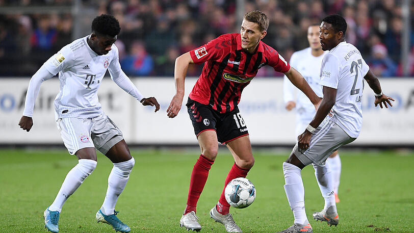 Nils Petersen (Mitte, SC Freiburg) am Ball gegen David Alaba (re, FC Bayern) und Alphonso Davies (li, FC Bayern).
