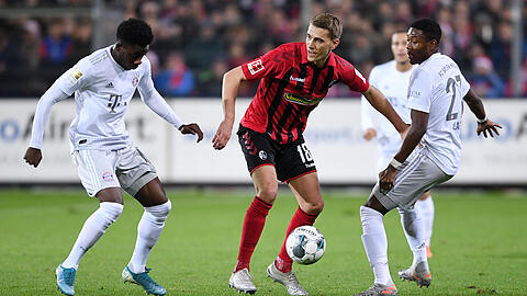 Nils Petersen (Mitte, SC Freiburg) am Ball gegen David Alaba (re, FC Bayern) und Alphonso Davies (li, FC Bayern).