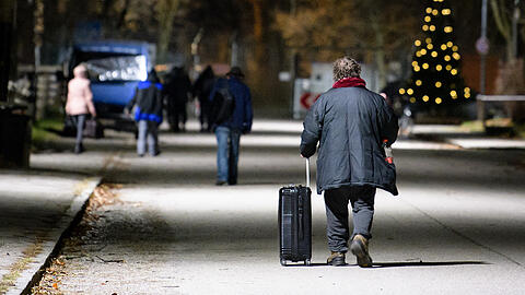 Obdachlose gehen  über das Gelände der Bayernkaserne in München. (Archivbild)