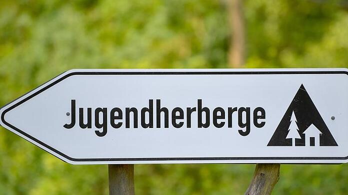 Ein Schild weist auf eine Jugendherberge hin.