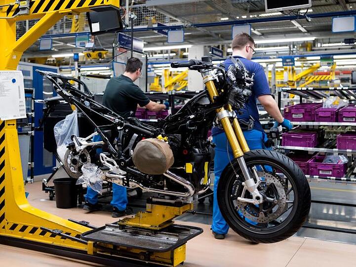 Werkmitarbeiter bauen auf einer Montagelinie im BMW-Werk in Berlin Motorräder zusammen. Foto: picture alliance / Monika Skolimowska/dpa/Archivbild