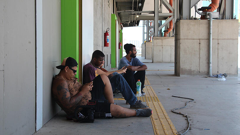 Jugendliche sitzen vor der Arena do Futuro (Zukunftsarena) in Rio de Janeiro (Brasilien). Hier fanden die Handballwettkämpfe statt.