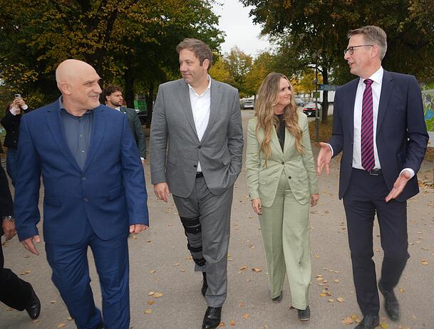 Projektleiter Kai Zosseder (l.), Lars Klingbeil (SPD), Mona Fuchs (Gr&uuml;ne) und Wissenschaftsminister Markus Blume (CSU) im Olympiapark.