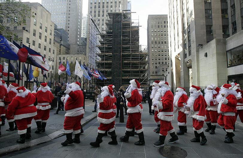 Fünf Tage vor dem feierlichen Anzünden der Lichter waren New Yorks Weihnachtsmänner an der Fichte vorbeimarschiert. Bei der alljährlichen "Sidewalk Santa Parade" sammelten sie Spenden.