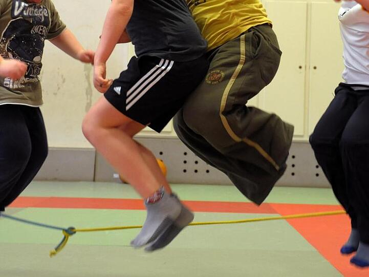 In einer Sporthalle nehmen übergewichtige Kinder an einem Sportprogramm teil.