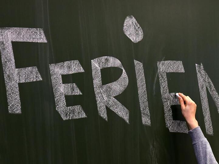 Das Wort "Ferien" wird mit Kreide auf einer Tafel in einer Schule geschrieben. Foto: Ralf Hirschberger/dpa-Zentralbild/dpa/Archivbild
