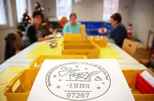 Der Stempel des einzigen bayerischen Weihnachtspostamtes ist am 22.11.2013 in Himmelstadt (Bayern) zu sehen, während im Hintergrund Briefe von Kindern an das Christkind sortiert werden.