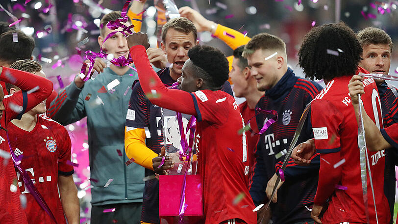 Triumph beim Telekom Cup: Manuel Neuer übergibt Alphonso Davies die Trophäe.