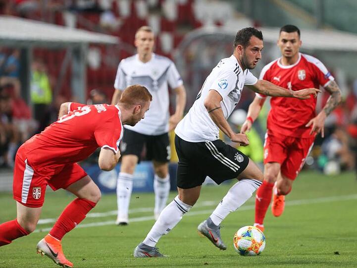 Levin Öztunali (M) aus Deutschland spielt den Ball an Miroslav Bogosavac (l) aus Serbien vorbei.