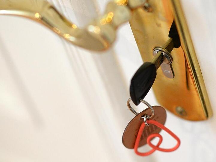 Ein Schlüssel steckt im Schloss einer Airbnb-Ferienwohnung. Foto: Jens Kalaene/Archiv
