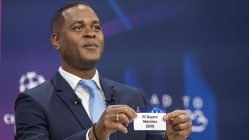 Der ehemalige niederländische Fußballspieler  zeigt ein Ticket des FC Bayern München während der Auslosung der UEFA Champions League.