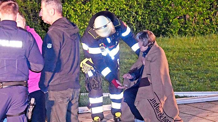 Die Feuerwehr versorgt verletzte Bewohner nach einem Hochhausbrand in Sendling.