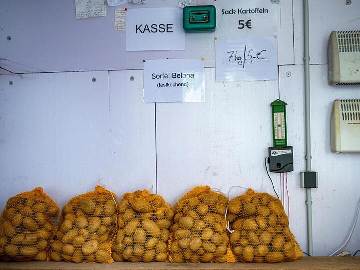 Kartoffeln stehen in einen Verkaufsstand bei einem Landwirt auf dessen Hof.