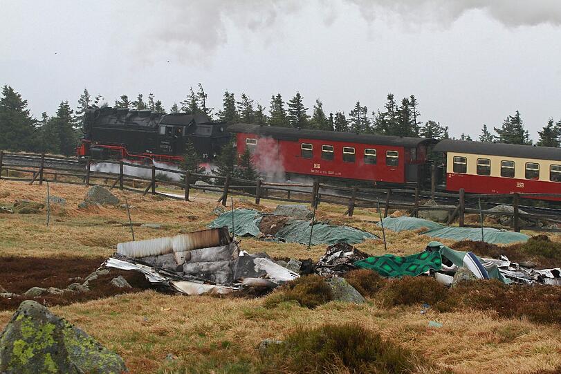 Ein Kleinflugzeug ist auf dem Brocken abgestürzt. Ein Zug der Harzer Schmalspurbahn fährt an der Absturzstelle vorbei. Nach Polizeiangaben sind bei dem Absturz der Maschine am Morgen zwei Menschen ums Leben gekommen. Nach Angaben eines Mitarbeiters der Wetterwarte auf dem Brocken prallte das Flugzeug gegen einen 27 Meter hohen Mast der Station. Polizei und Spezialkräfte untersuchen derzeit die Unfallstelle.