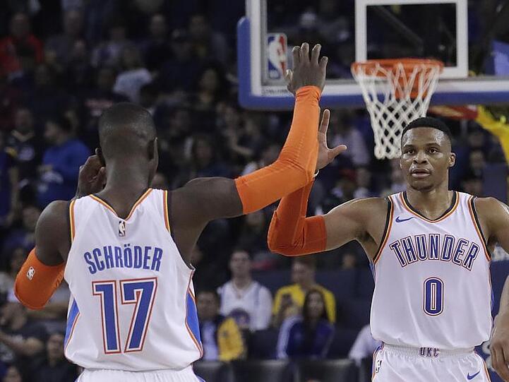Russell Westbrook (M) klatscht mit Dennis Schröder ab. Beide holten 30 Zähler für Oklahoma im Spiel gegen Charlotte.