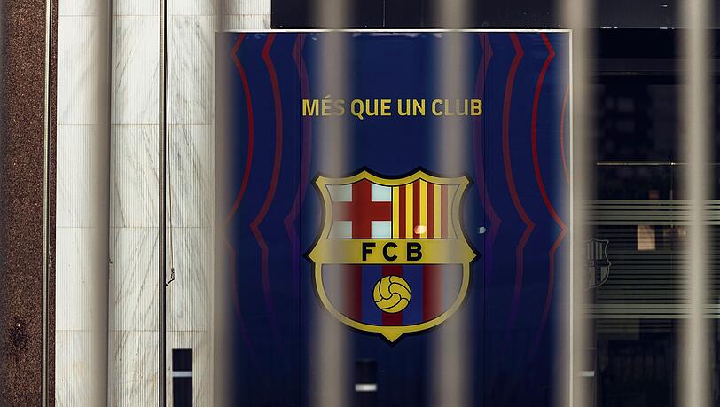 Blick auf das Wappen des FC Barcelona hinter den geschlossenen Toren des Camp Nou Stadions.