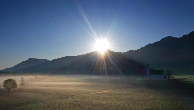 Die Sonne geht über den Bergen hinter der Wallfahrtskirche Sankt Coloman auf. Foto: Karl-Josef Hildenbrand/dpa Die Sonne geht über den Bergen hinter der Wallfahrtskirche Sankt Coloman auf. Foto: Karl-Josef Hildenbrand/dpa