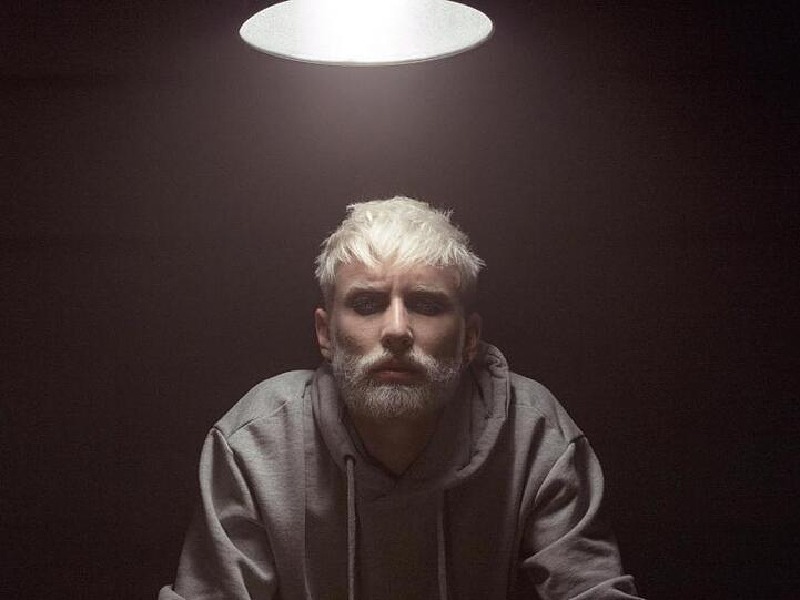 Tom Neuwirth jetzt mit blondem Bart und Kurzhaarfrisur wirbt für das Musikprojekt Wurst.