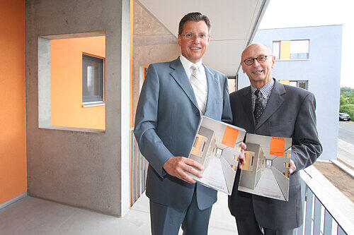 In Nürnberg wird zu wenig Wohnraum gebaut: Wirtschaftsreferent Roland Fleck (li.) und Wohnungsamts-Chef Hans-Joachim Schlößl präsentieren den Wohnungsbericht vor dem Wbg-Projekt "Wohnen in allen Lebensphasen", das auch den Titel der Broschüre ziert.