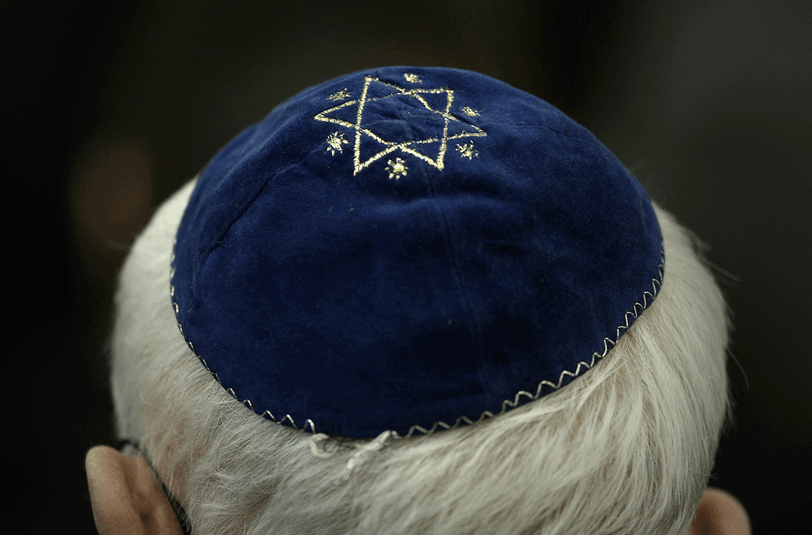 Ein Mann trägt in der Synagoge in Mainz (Rheinland-Pfalz) eine Kippa mit einem aufgenähtem Stern.